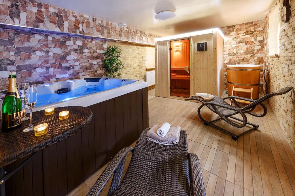 a large bathroom with a tub with a table and chairs at Apartmány Andrea s wellness in Zdíkov