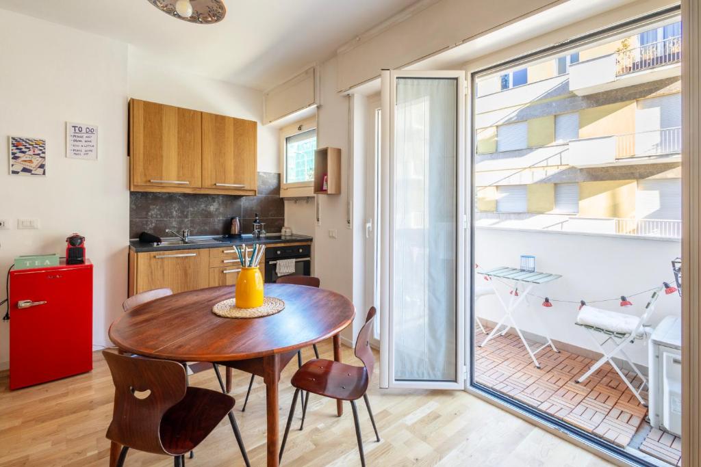 a kitchen with a wooden table and a red refrigerator at Bindarella ai Navigli in Milan
