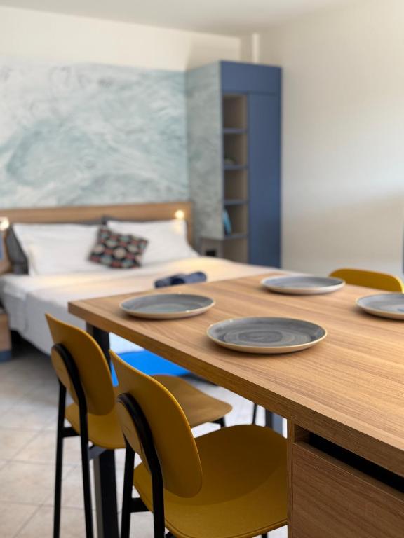 a room with a table with chairs and a bed at Casa Merano Residence & Restaurant Bibione - New suites in Bibione