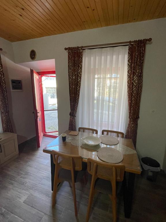 a dining room with a table and chairs and a window at Kıymet Aydogdu in Alaçatı