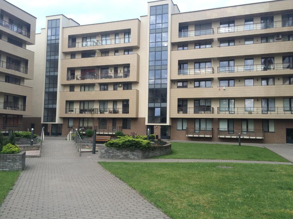 ein großes Gebäude mit Rasen davor in der Unterkunft Luxury Apartment in Druskininkai