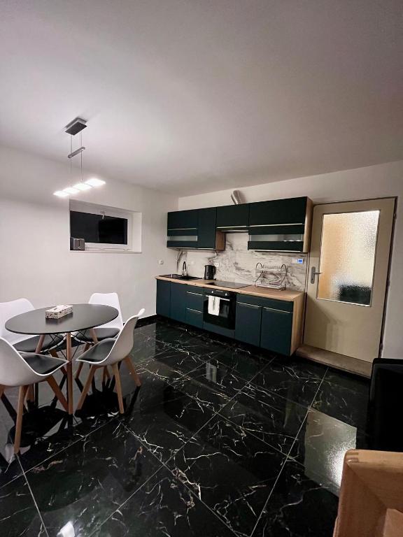 a kitchen with green cabinets and a table and chairs at ZANIK Cozy Haven in Prague