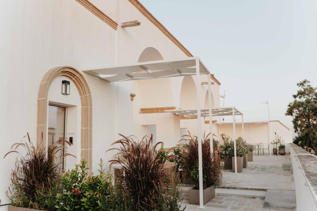 an outside view of a church with potted plants at Corte Vespro in Ugento