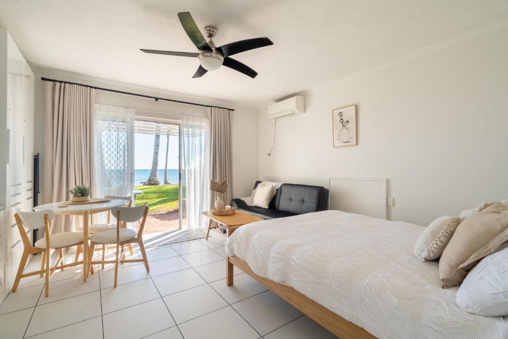 a bedroom with a bed and a table and a dining room at Lousha Bach Dolphin Heads in Eimeo