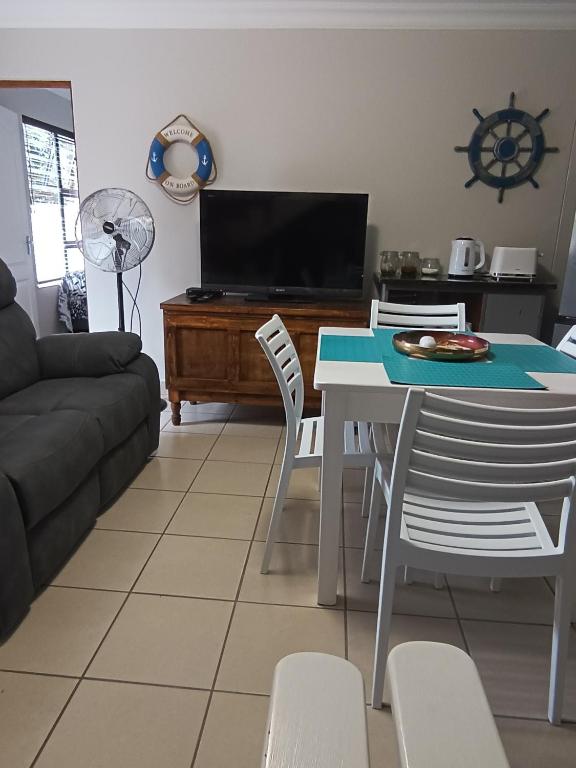 a living room with a table and chairs and a tv at J&B Tuiste in Reebok