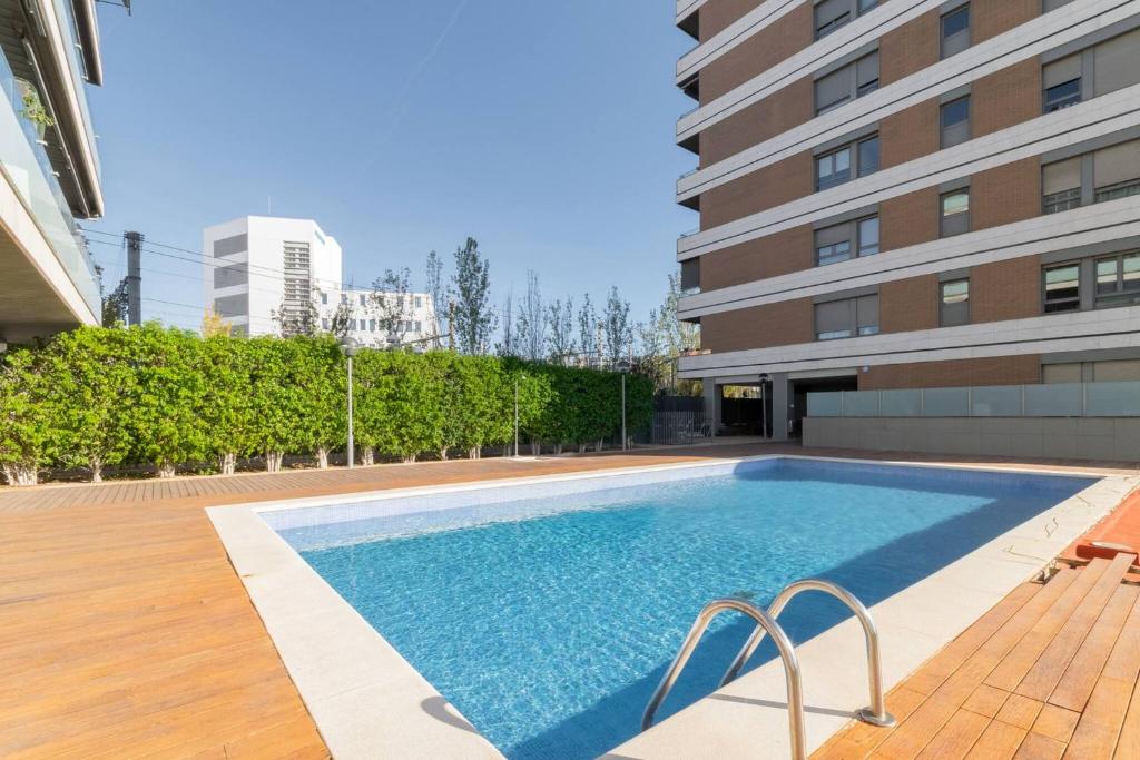 a swimming pool in front of a building at Penthouse with Private Terrace & Pool Access in Cornellà de Llobregat