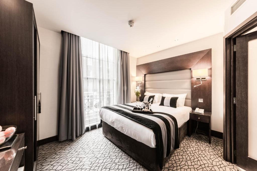 a hotel room with a bed and a dresser at Park Avenue Baker Street in London
