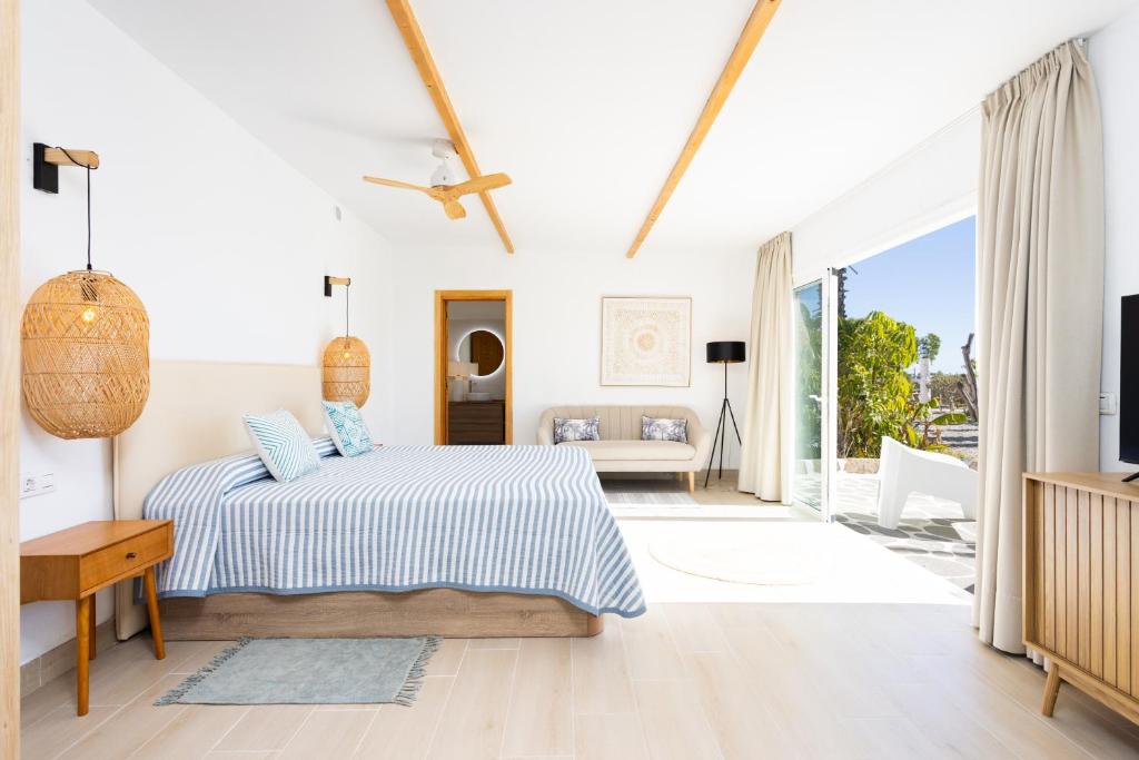 a white bedroom with a bed and a large window at Eden Rentals Costa Boho 2 in Las Galletas