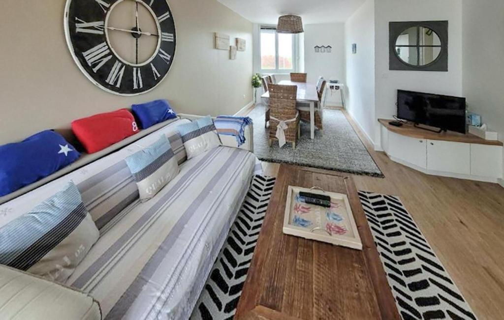 a living room with a couch and a large clock at Superbe Appartement Vue Mer in Dunkerque