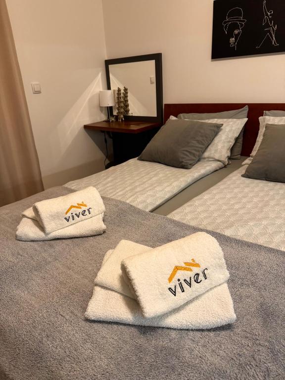 two beds with towels on them in a room at Apartmani Viver Vrnjačka Banja in Vrnjci