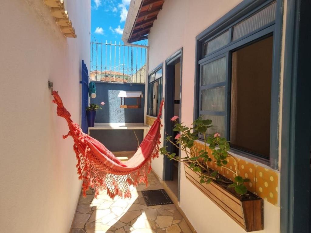 a hammock in a room with a balcony at Costa Family-Little house in the center in Santa Rita do Sapucaí