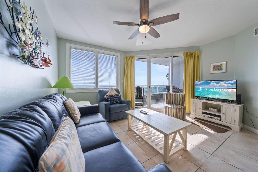 a living room with a blue couch and a tv at Silver Beach 104 PET FRIENDLY! in Orange Beach