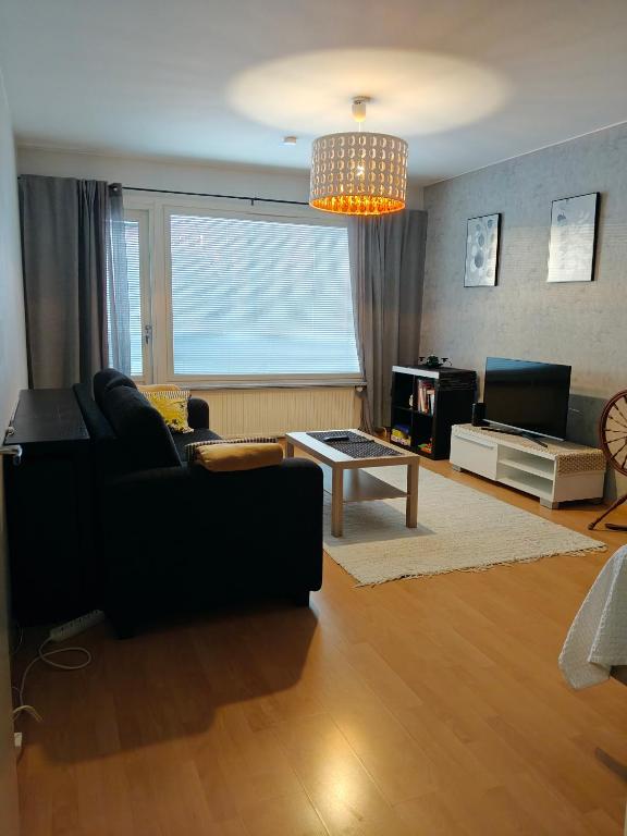 un soggiorno con un divano e un tavolo di Peaceful and spacious apartment with free parking a Kemi