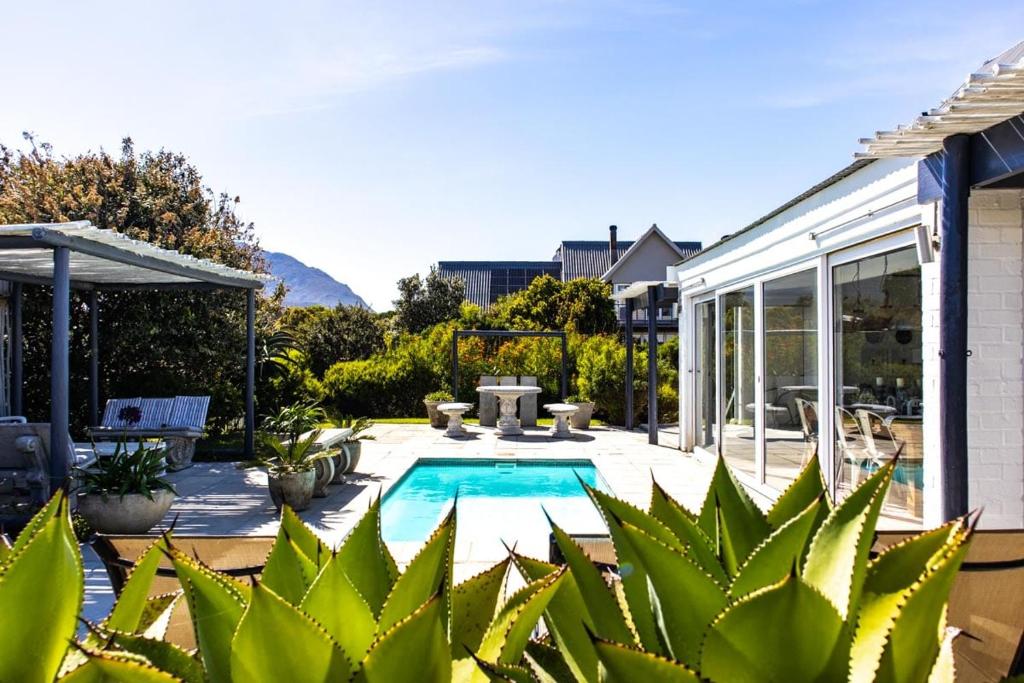 a backyard with a swimming pool and a house at The Bay Cottage in Pringle Bay