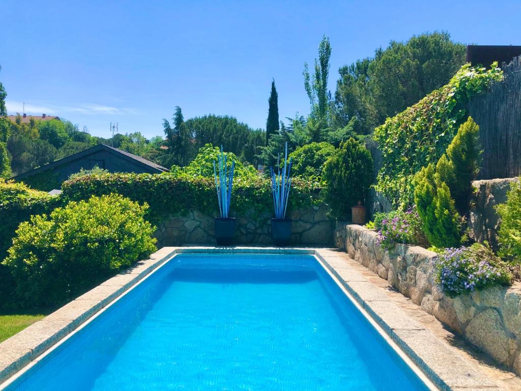 a swimming pool in a garden with two fountains at Charming villa with a private pool in Las Rozas de Madrid