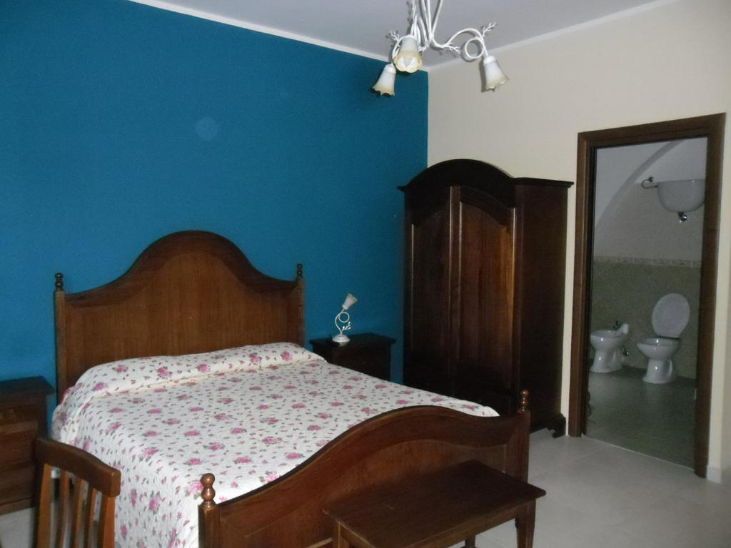 1 dormitorio con cama y pared azul en B&B Il Laghetto, en Serra San Bruno