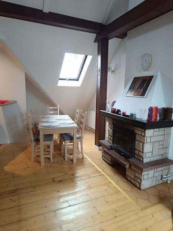 a dining room with a table and a fireplace at Paula Apart in Wadowice