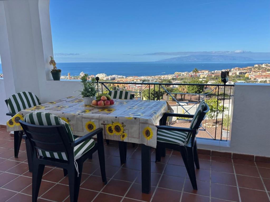 a dining room table with chairs and a view of the ocean at Panoramic View Balcón del Atlántico in Adeje