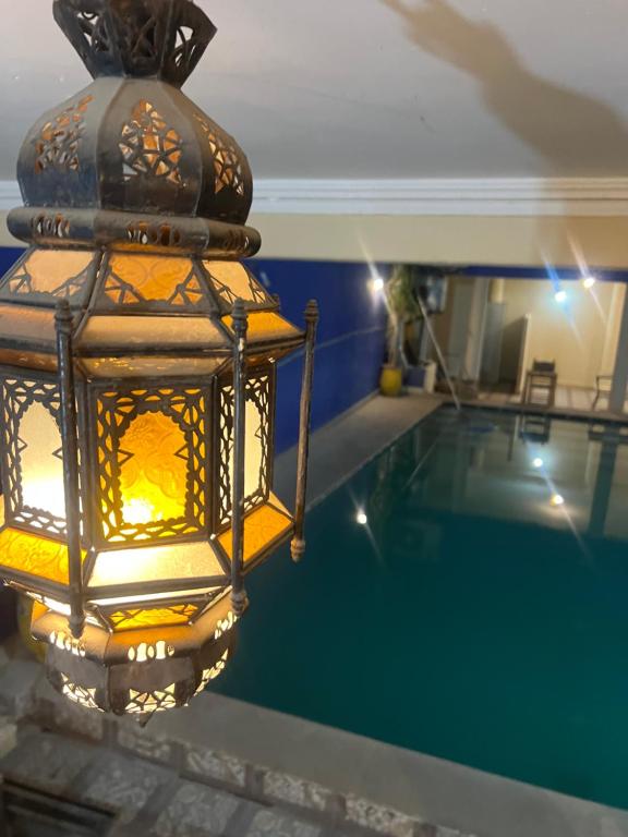 a chandelier hanging over a swimming pool at Hotel Appart HB in Marrakesh