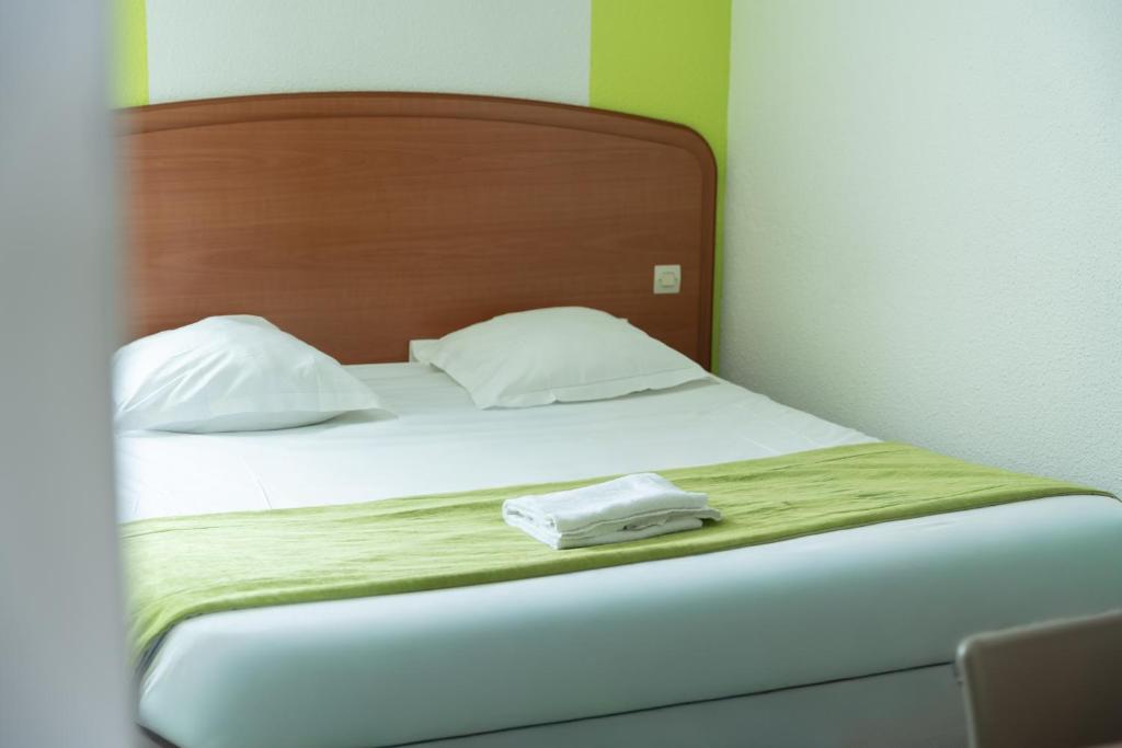 a bed with two towels sitting on top of it at Bhoma Budget Troyes aéroport in Troyes