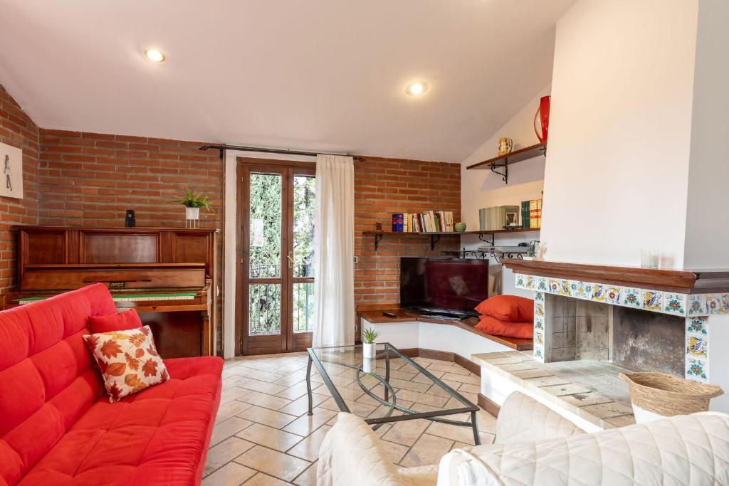 a living room with a red couch and a fireplace at Italian Experience-Casa Miramonti in Perugia
