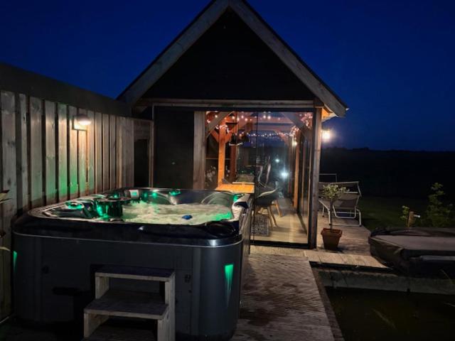 a jacuzzi tub on the side of a house at B&B Groene oase in Bantega