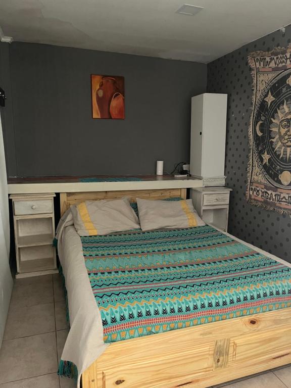a bed with a wooden frame in a bedroom at dpto lofalu in Gobernador Gregores