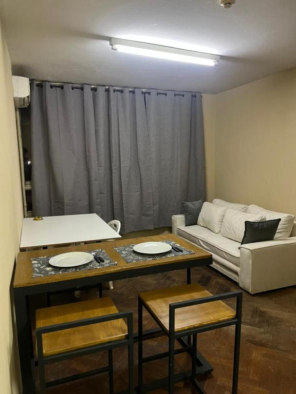 Una sala de estar con una mesa y sillas y un sofá. en Edificio en el Casco Historico, en Asunción