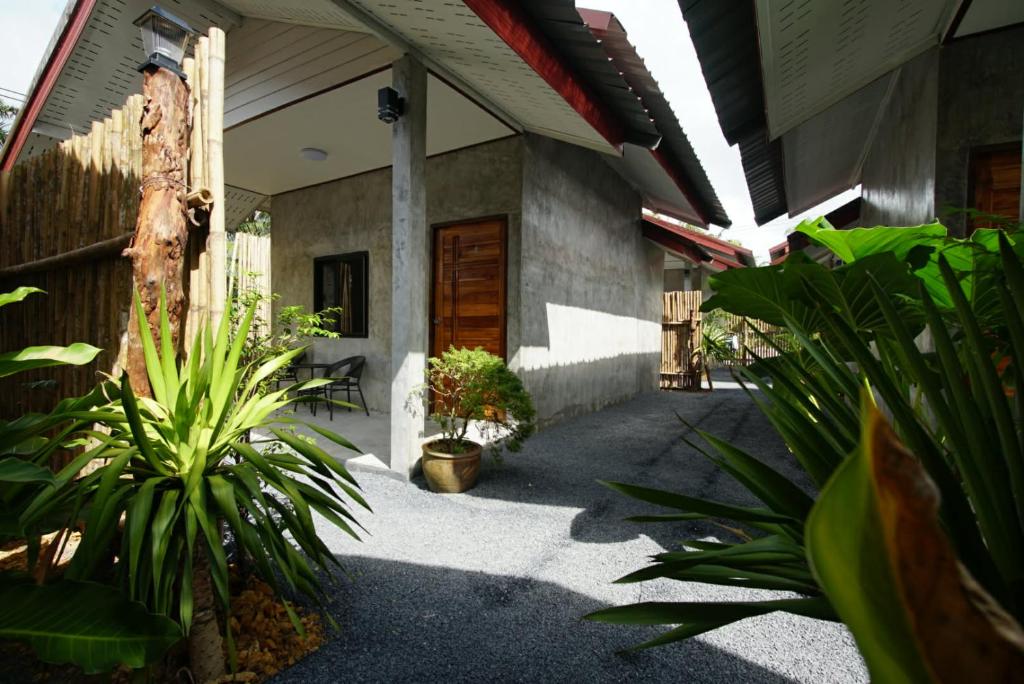 a courtyard of a house with plants and a door at Krabi Aonang happy resort in Ao Nam Mao