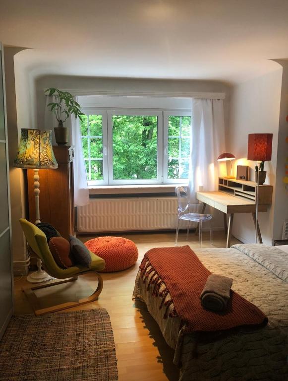 a bedroom with a bed and a desk and a window at Villa des Bois Sauvages in Liège