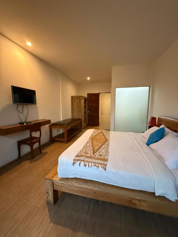a bedroom with a large bed and a desk at The Secreet Garden Hotel in Denpasar