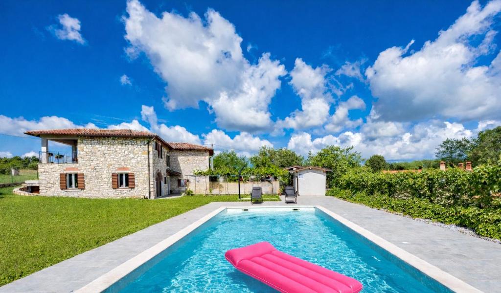 a pool with two inflatables in front of a house at Old Stone Villa Katarina in Nedeščina