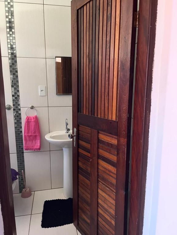 a bathroom with a wooden door and a sink at Pousada da Salete in Campo Mourão