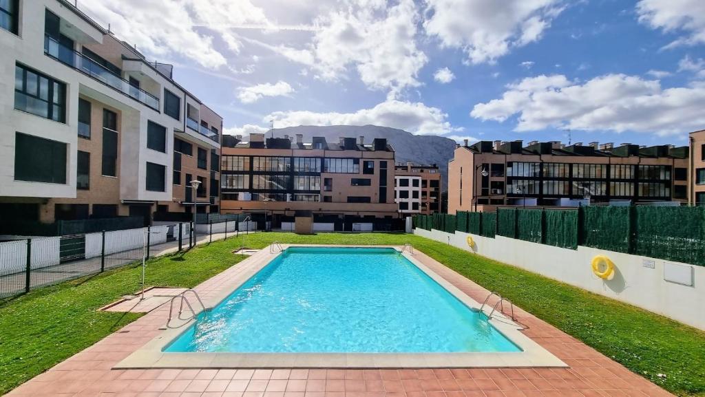 a swimming pool in the middle of a city with buildings at Apartamento El Picu con piscina in Posada de Llanes