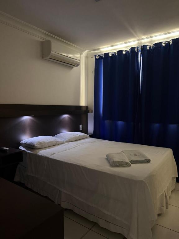 a bedroom with a bed with a blue curtain at Hotel Sol Brasil in Fortaleza