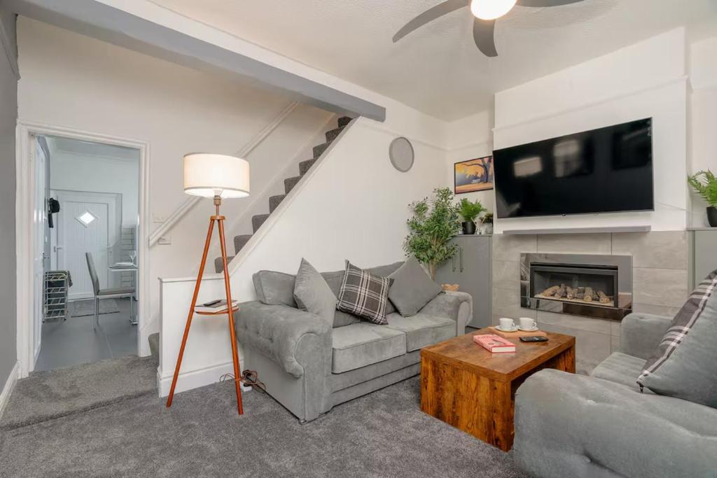 a living room with two couches and a fireplace at Family-Friendly 2-Bed Home with Games & Fireplace in Colne