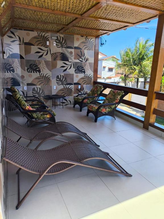 a patio with chairs and a hammock on a balcony at Pousada Jubarte in Serra