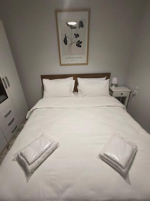 a white bed with two white towels on it at Stylish Suite in Larisa