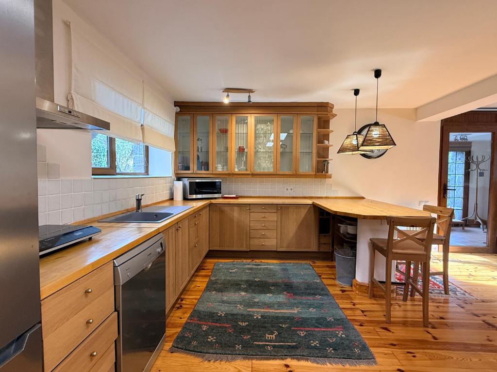 a kitchen with wooden cabinets and a table with a rug at Espacioso e independiente apartamento in Las Rozas de Madrid