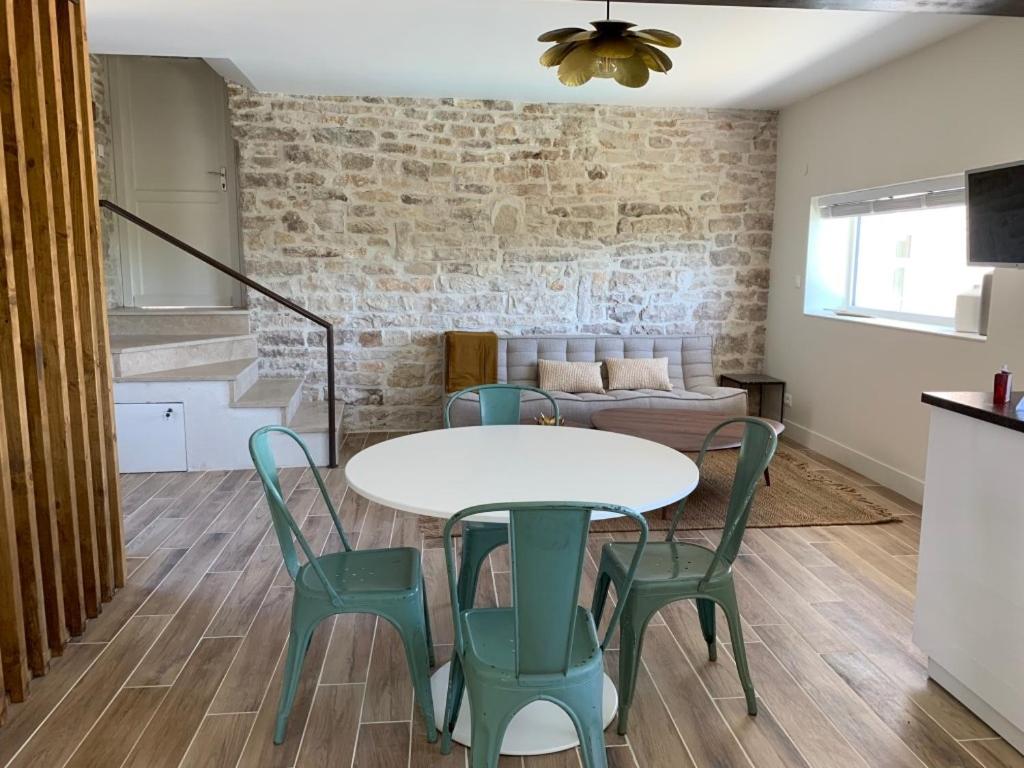 a living room with a table and chairs and a couch at L'Annexe Deveney-Mars in Puligny-Montrachet