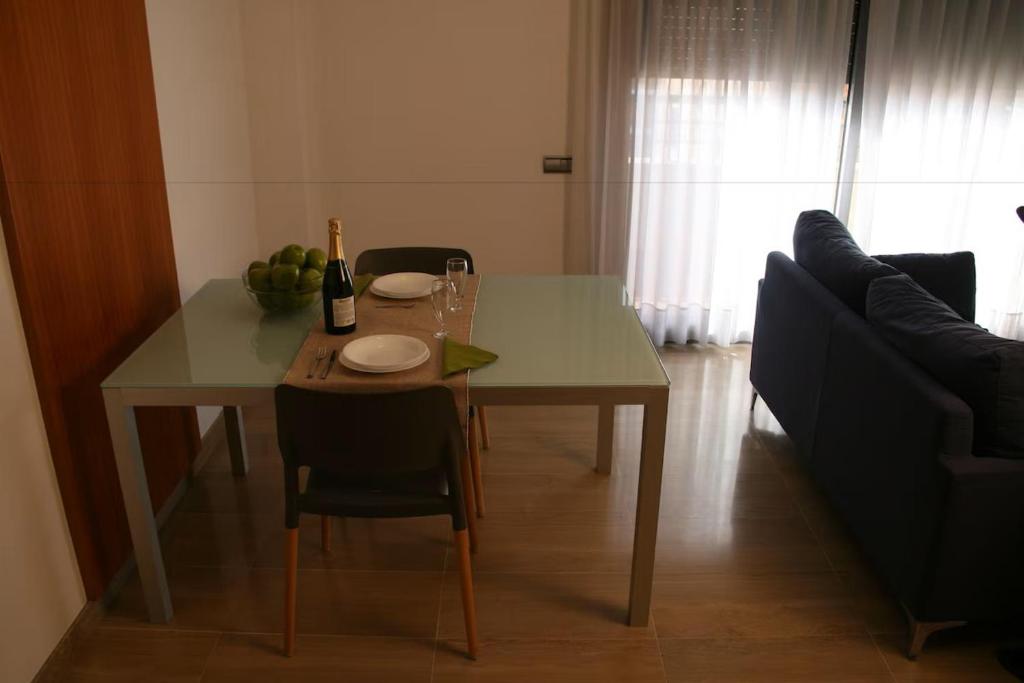 a dining room table with a bottle of wine and a wine glass at AmurResidence free parking in Iaşi