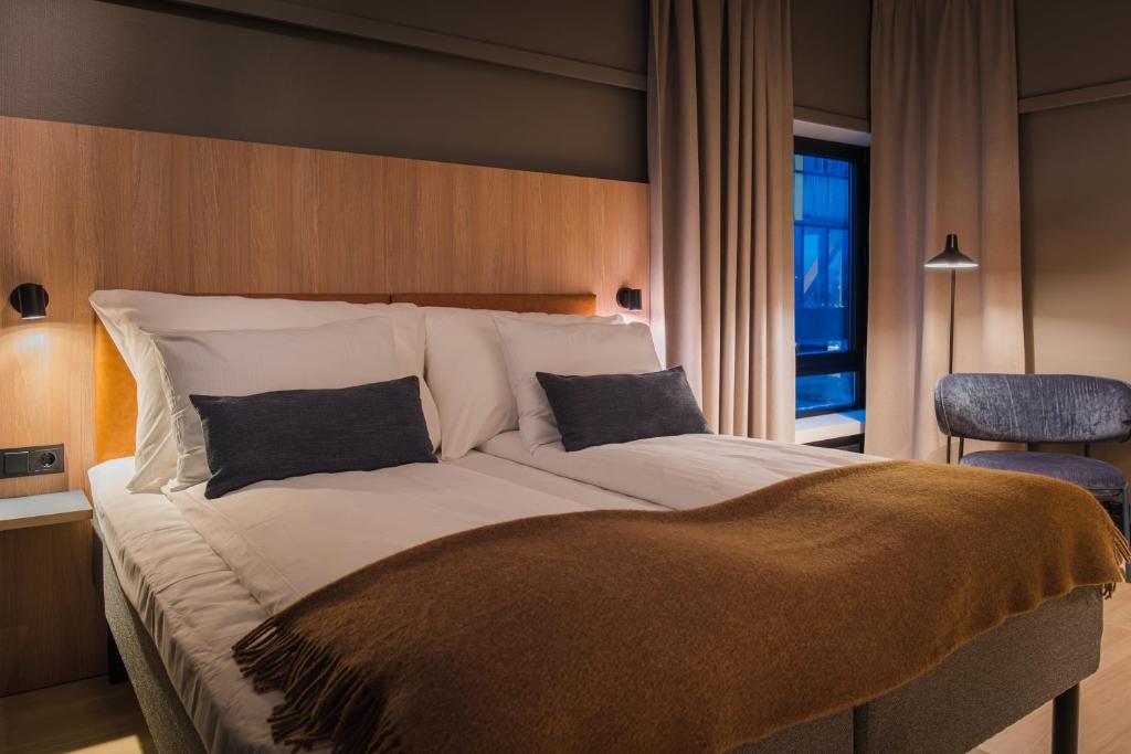 a large bed with two pillows on it in a bedroom at Quality Hotel Grand Steinkjer in Steinkjer