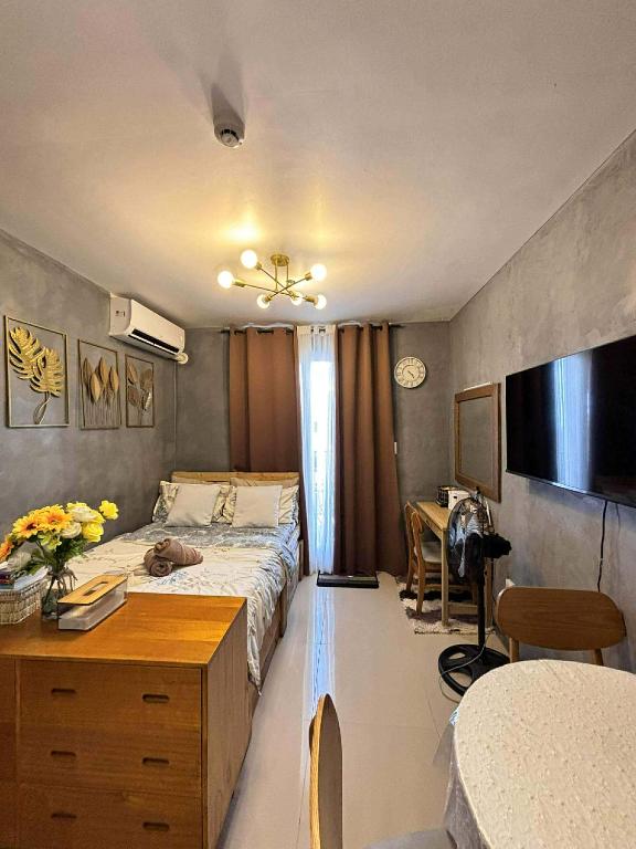 a bedroom with a bed and a dresser and a desk at Cozee Staycations in Lapu Lapu City