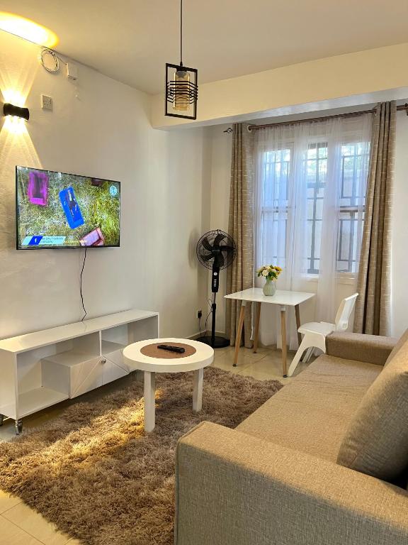 a living room with a couch and a table at Stylish 1br Milimani in Kisumu