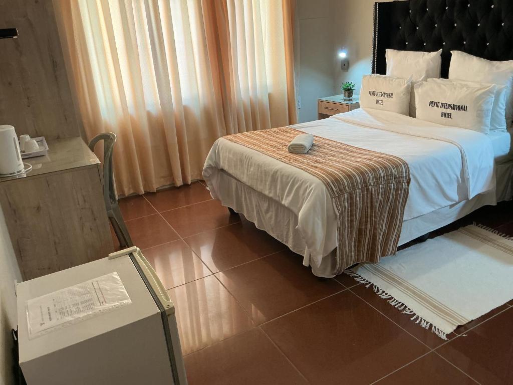 a hotel room with a bed and a table at Punyu International Hotel 