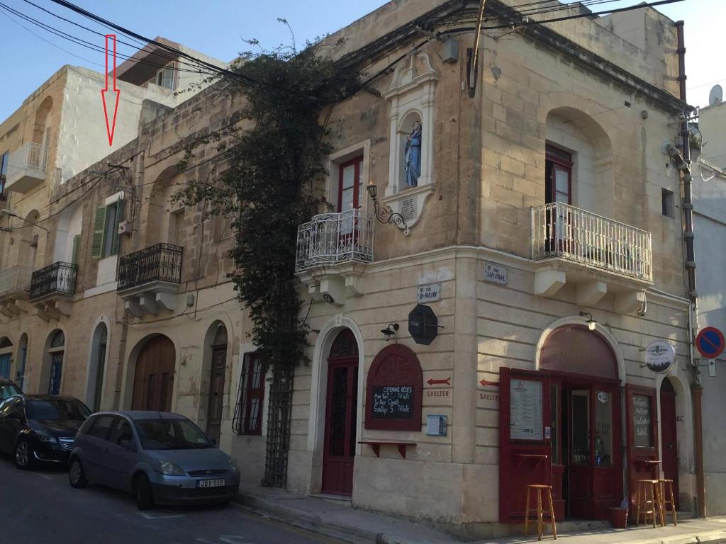 a building with a car parked in front of it at The 1930's Maltese Residence in St. Paul's Bay