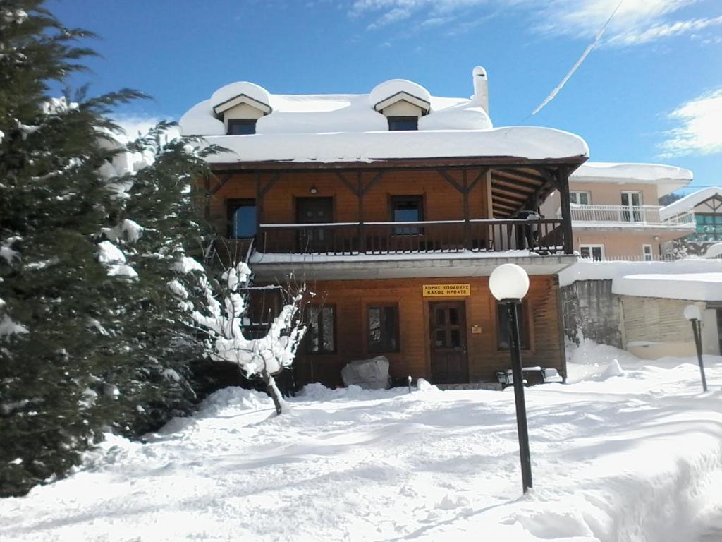 a building with snow on the ground in front of it at mezonetaki in Karpenisi