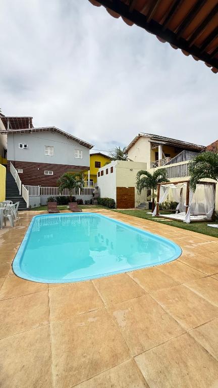 a large blue swimming pool in a yard at Pousada Linhares in Canoa Quebrada