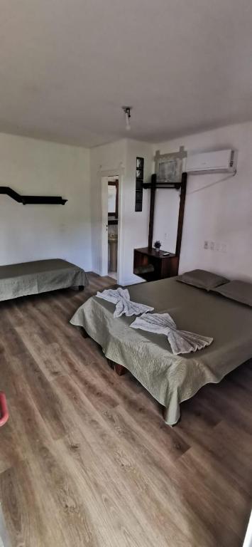 a room with two beds and a wooden floor at Verde & Sal 12 in Ilhéus