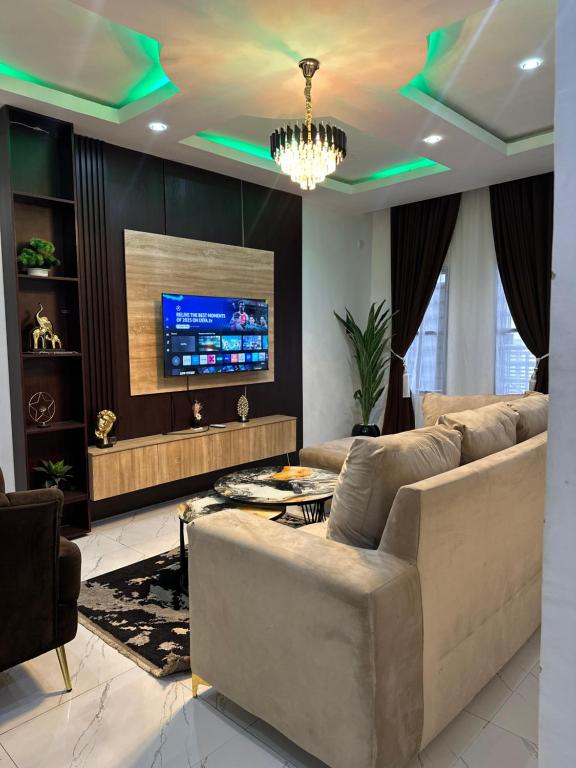 a living room with a couch and a tv at The NookHouse in Calabar